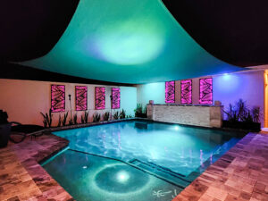 Custom Pool with stone deck at night and a canopy cover