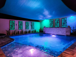 Custom pool in St. Petersburg, Florida area at night with custom lighting creating a blue effect | Winway Pools