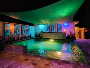 Custom pool at night with green and blue lighting in the St. Petersburg, Florida area
