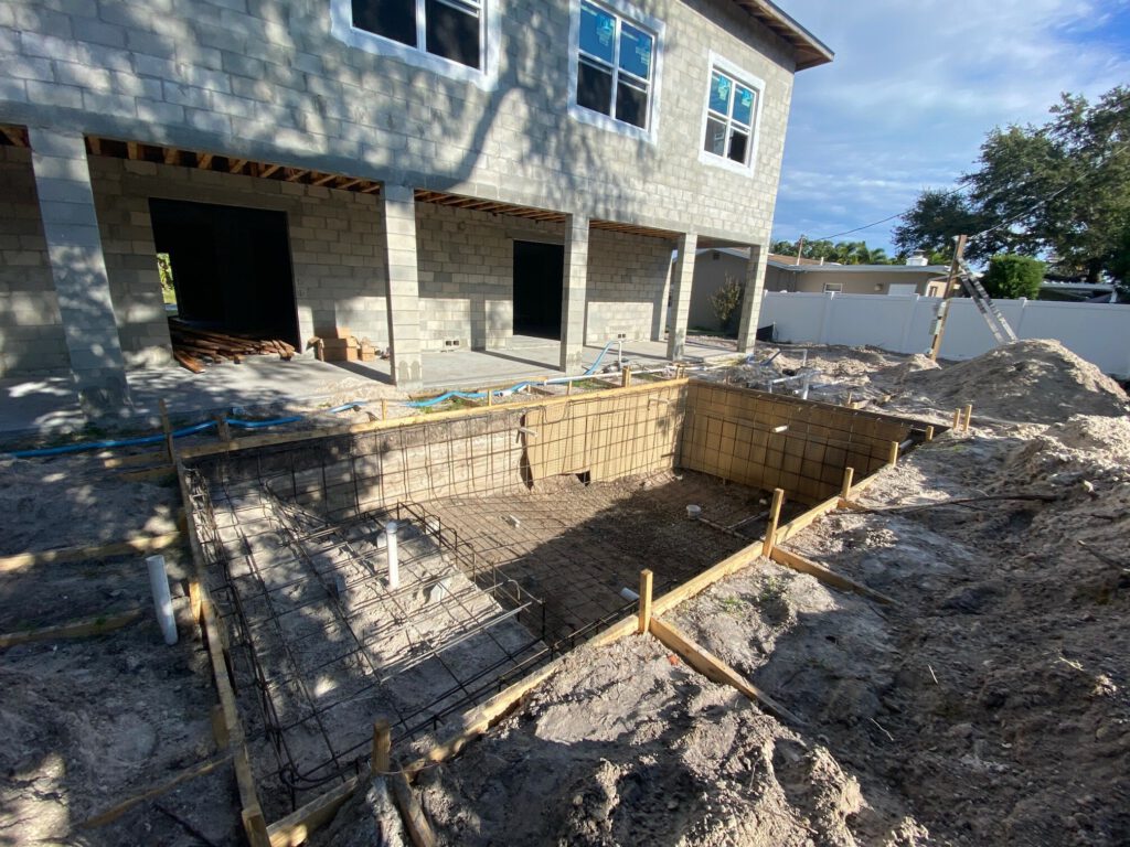 Swimming pool being constructed with a new home also being constructed in the St. Petersburg Florida area.
