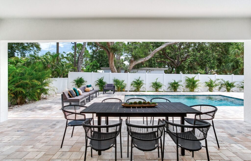 Custom pool behind outdoor table and chairs | Winway Pools