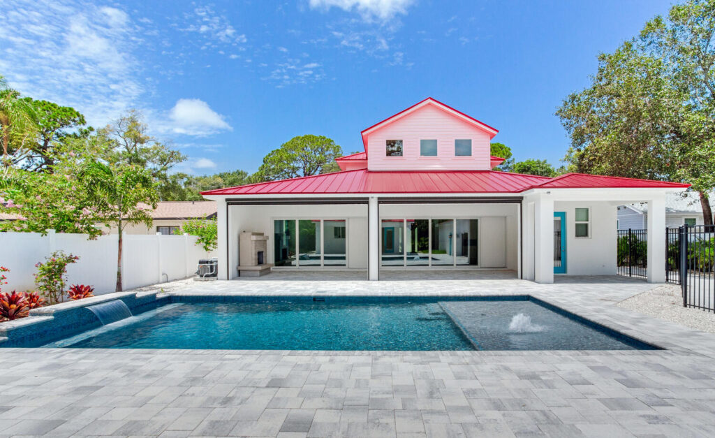 Custom pool with red-roof main house full view | Winway Pools
