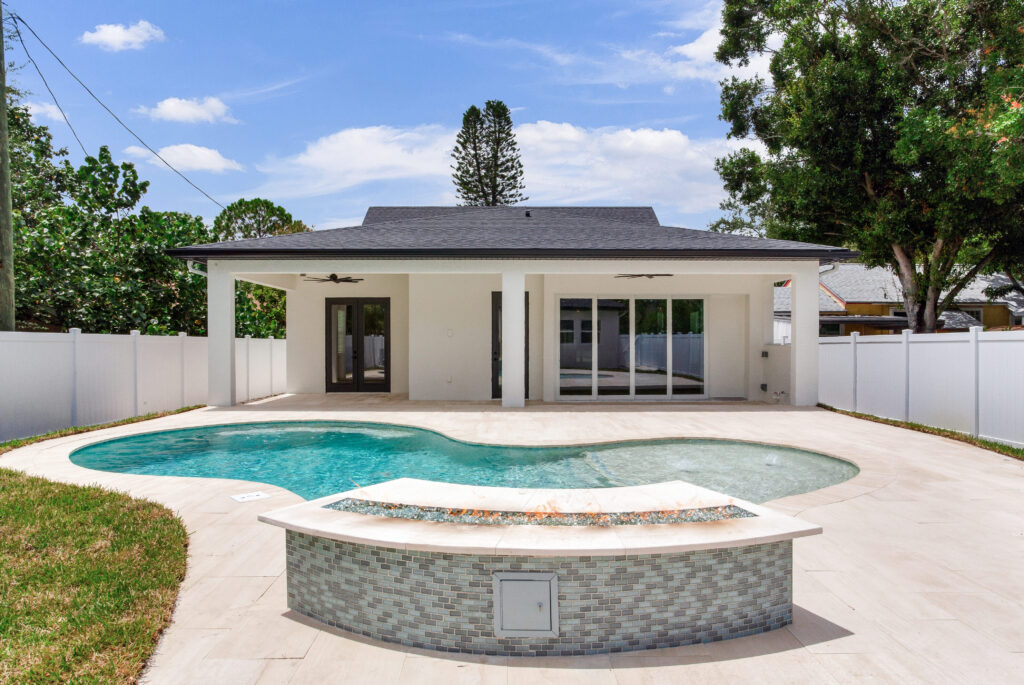 Custom pool with fireplace behind house | Winway Pools