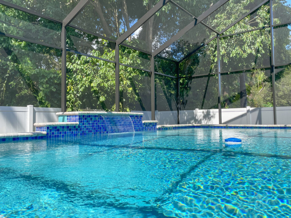 Custom pool waterfall under glass canopy | Winway Pools