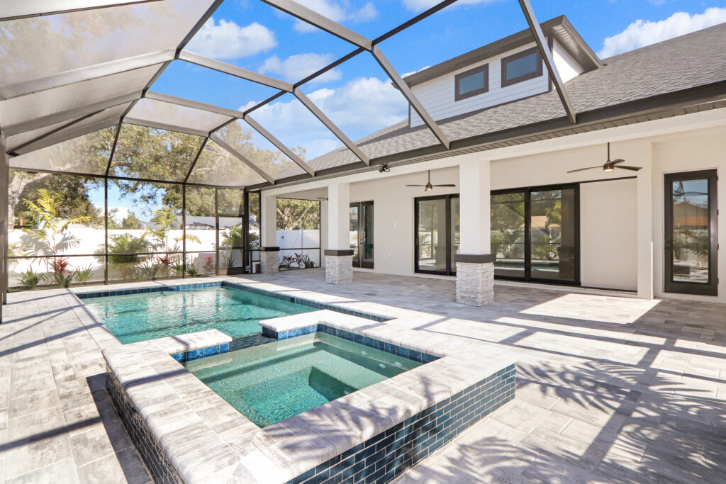 Custom spa and pool under glass canopy behind house | Winway Pools