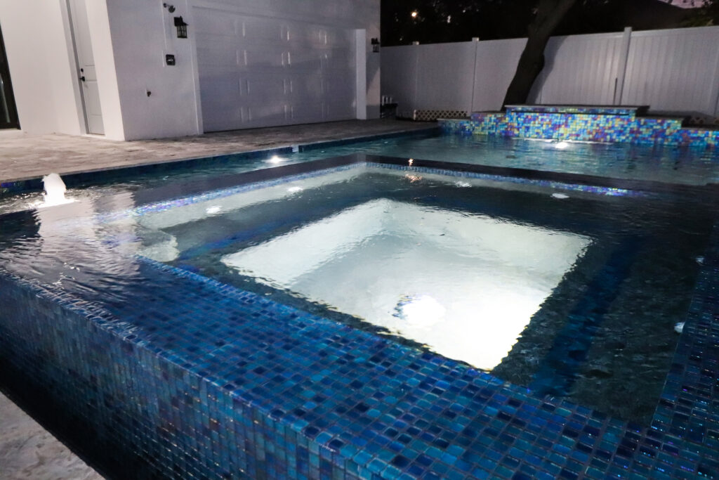 Custom spa with pool nighttime | Winway Pools