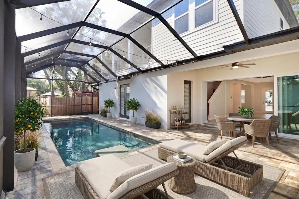 Custom pool with paver patio and screen cover.