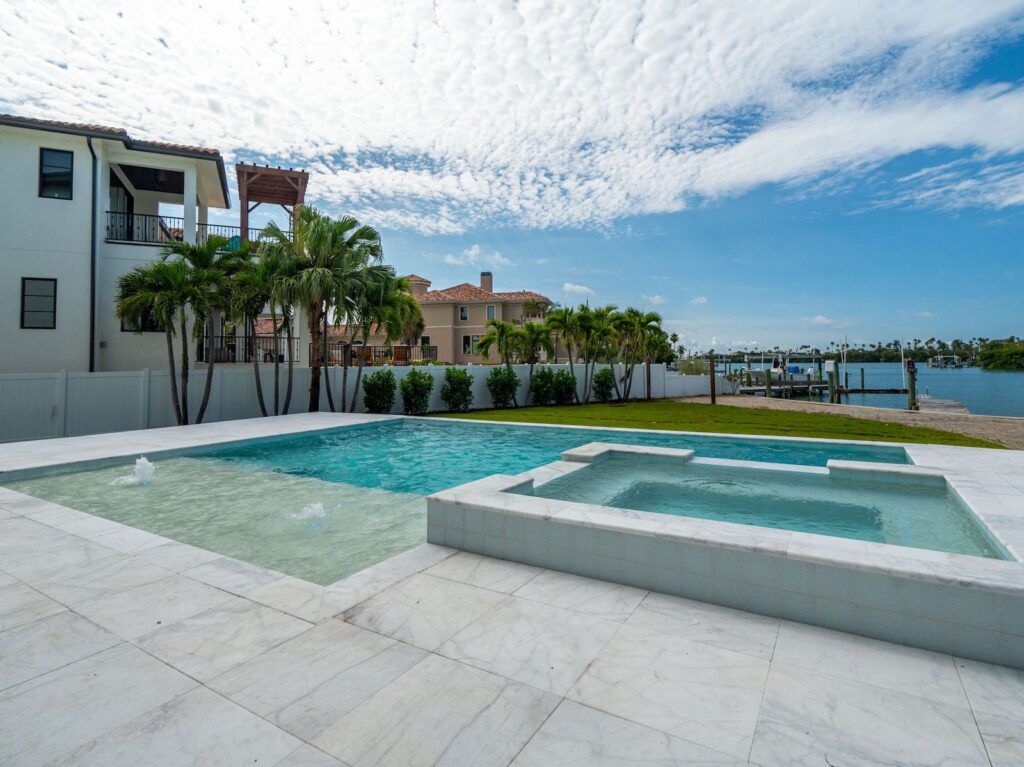 Waterfront custom pool and spa with expansive patio overlooking a Florida canal