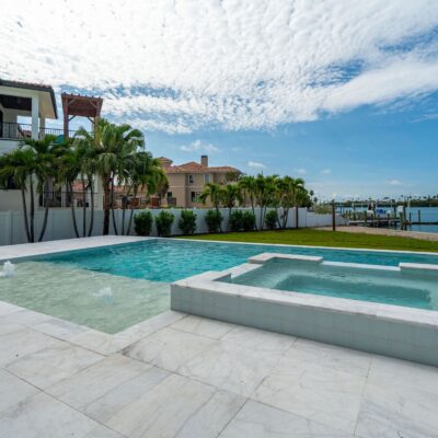 Waterfront custom pool and spa with expansive patio overlooking a Florida canal