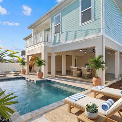 Custom swimming pool and covered outdoor living area beneath an elevated coastal home in Florida
