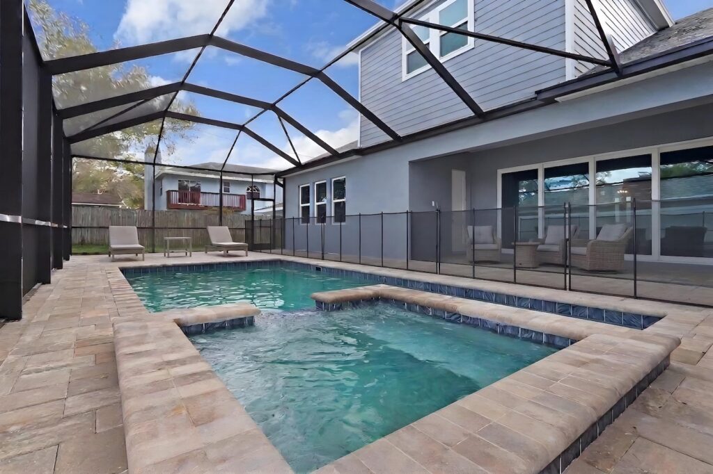 Custom freeform pool with decorative water bowls and tropical landscaping