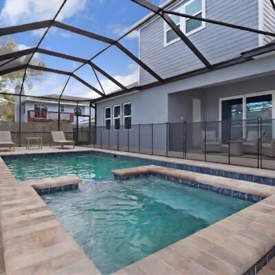 Custom freeform pool with decorative water bowls and tropical landscaping