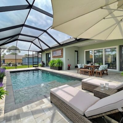 Covered outdoor living space with screened pool, lounge seating, and dining area