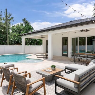 Freeform backyard pool with covered patio, outdoor seating, and contemporary poolside design