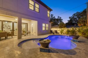 Stunning Outdoor Custom Pool at Twilight with Hardscape Framing Behind a New WinWay Home