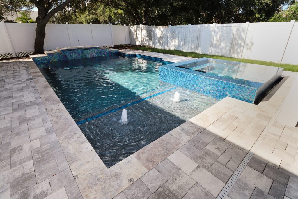 Contemporary Custom Pool by WinWay Pools St. Petersburgh with Bubblers and Spillover Spa with Tiled Patio Under Shade Try